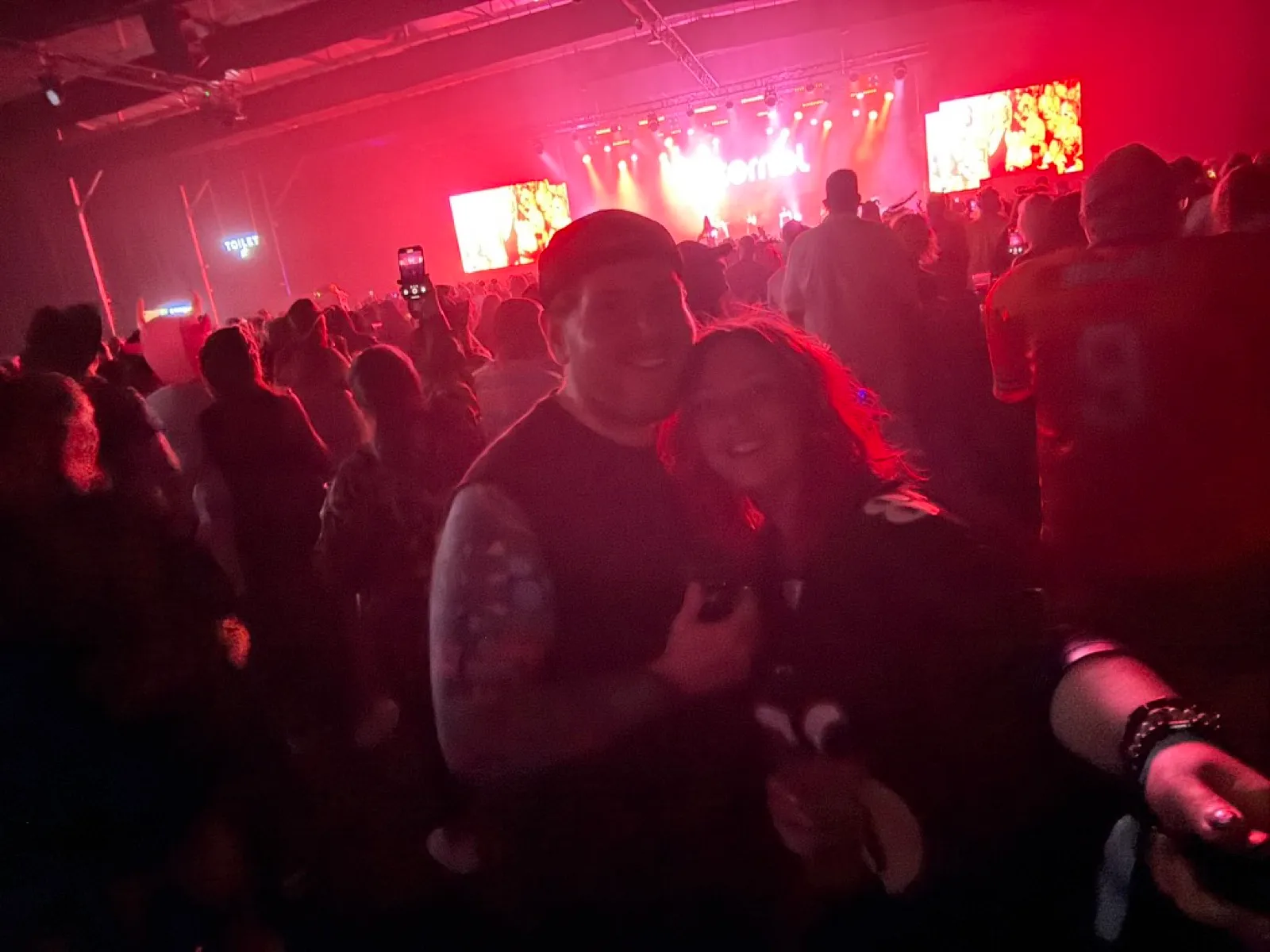 Crowd watching a live band in a red-lit venue at the Butlins 90s Reloaded Big Weekender