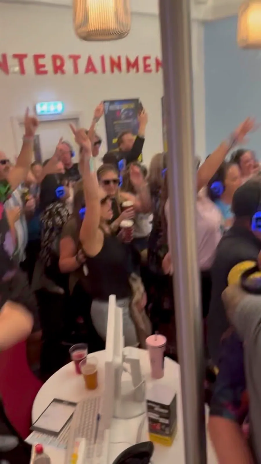 Silent disco crowd with glowing headphones on and arms in the air inside the Butlins Skegness pavilion