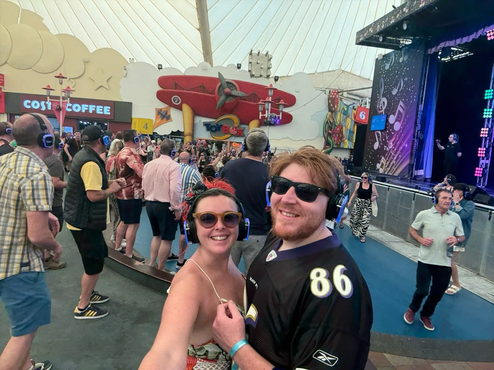 Two of us in silent disco headphones by the outdoor stage at Butlins Skegness, crowd dancing behind us