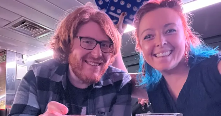 The two of us laughing at a table in the ship's bar, pints in front of us