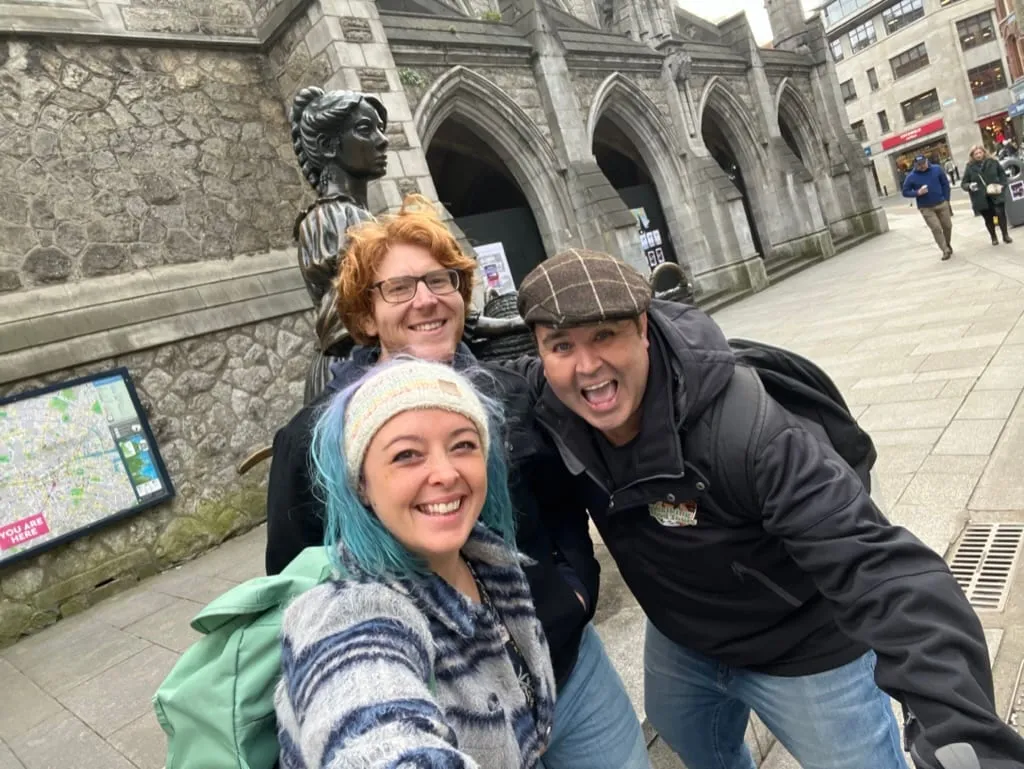The three of us squashed into a selfie by the Molly Malone statue in Dublin, Kevin in a flat cap grinning at the camera