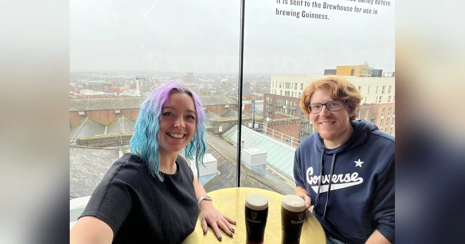 The two of us at a yellow table in the Gravity Bar with two pints of Guinness between us, Dublin rooftops through the window behind