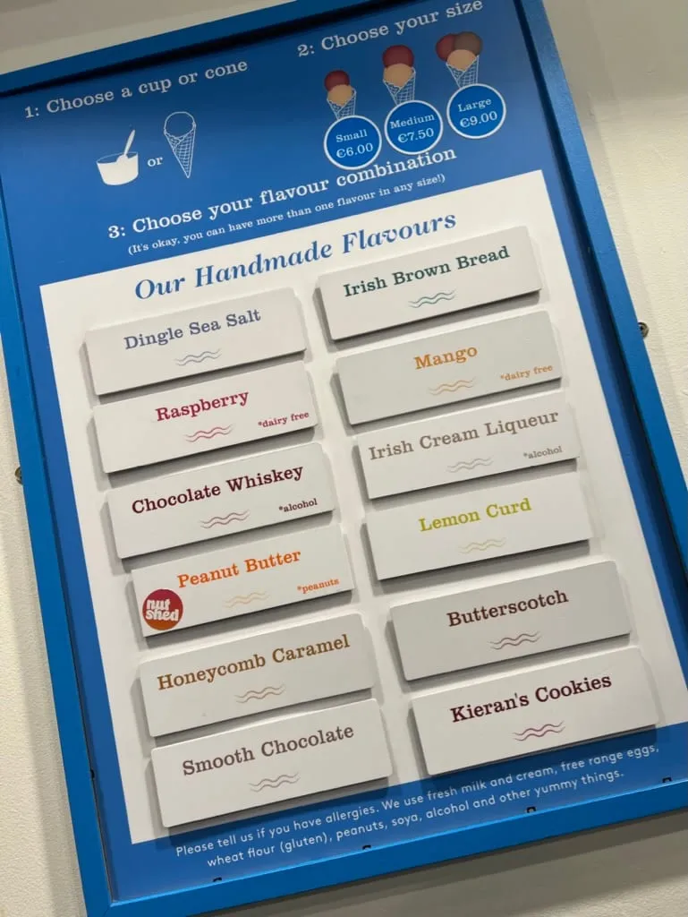 The handmade flavour board at the ice cream shop, listing Dingle Sea Salt, Irish Brown Bread, Chocolate Whiskey, Irish Cream Liqueur, Honeycomb Caramel, Butterscotch and more, with cup or cone sizes at six, seven fifty and nine euro