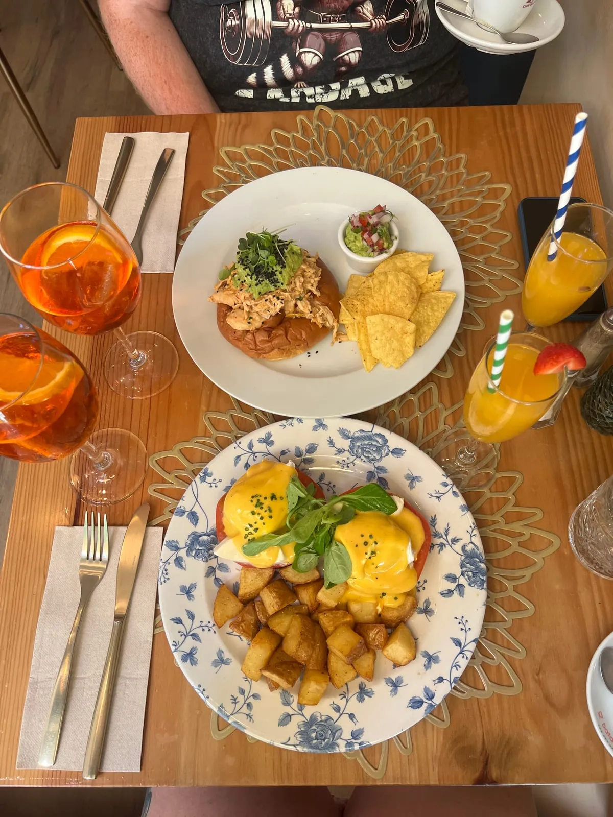 The Barcelona Eggs Benedict with crispy diced potatoes, next to the American Breakfast Sandwich with guacamole and tortilla chips, at The Florentine, Barcelona