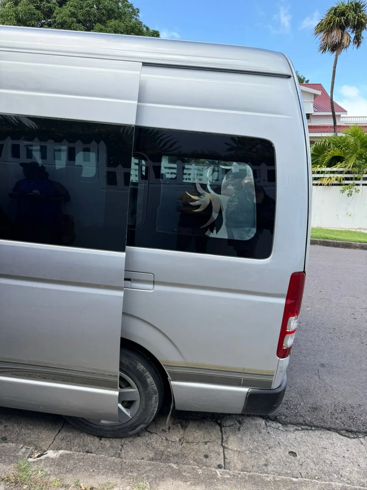 The silver minibus used for the Overland Drive excursion in St Kitts, with its rear side window covered by a sticker