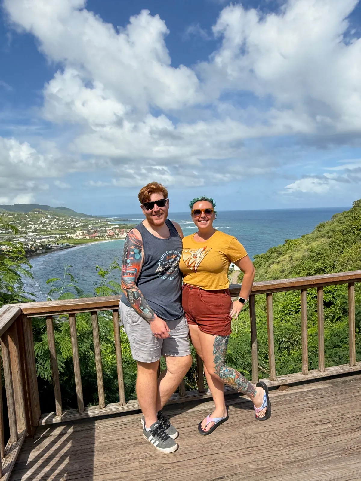 The two of us on a wooden viewing platform above the coast in St Kitts, with Frigate Bay and the Caribbean behind us