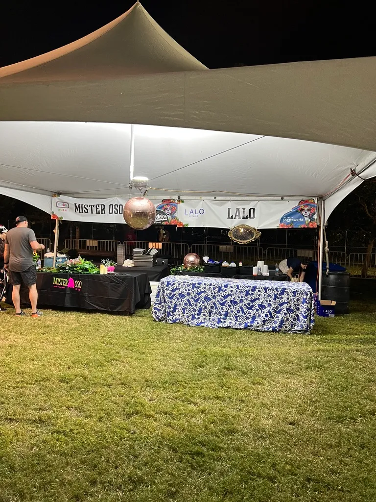 The Mister Oso and Lalo tent, a mirrorball hanging over tables dressed with blue and white patterned cloths and a gold framed mirror