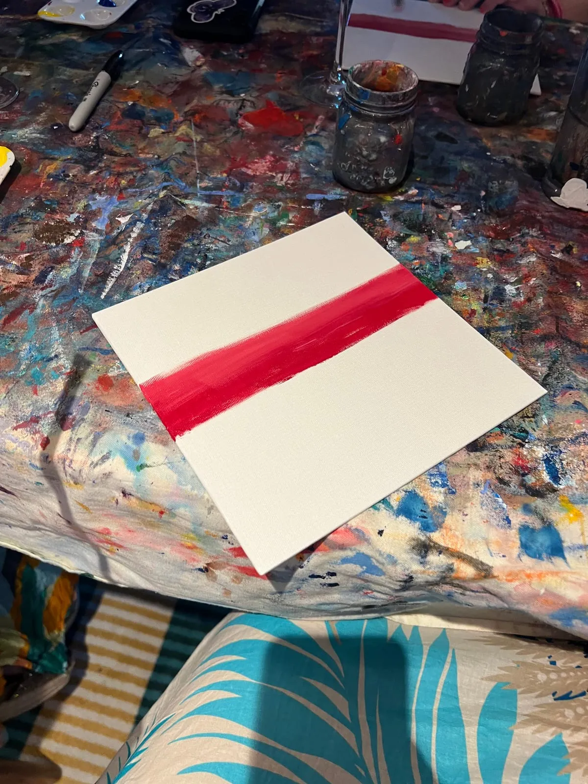 The very first step, a single broad red stripe painted across an otherwise blank white canvas