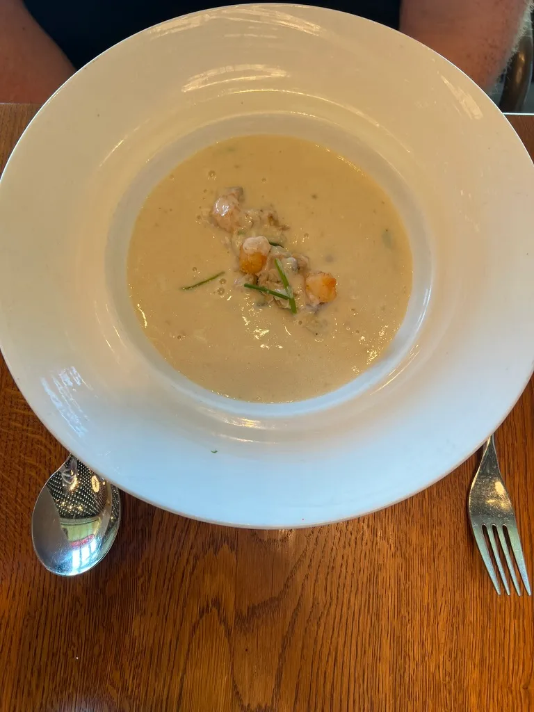 The clam chowder at The Wake: a wide white bowl of creamy pale chowder with clams and chives in the centre.