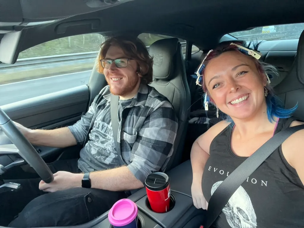 Alex driving with both hands on the wheel and me in the passenger seat with heated rollers still in my hair, two travel mugs in the cup holders