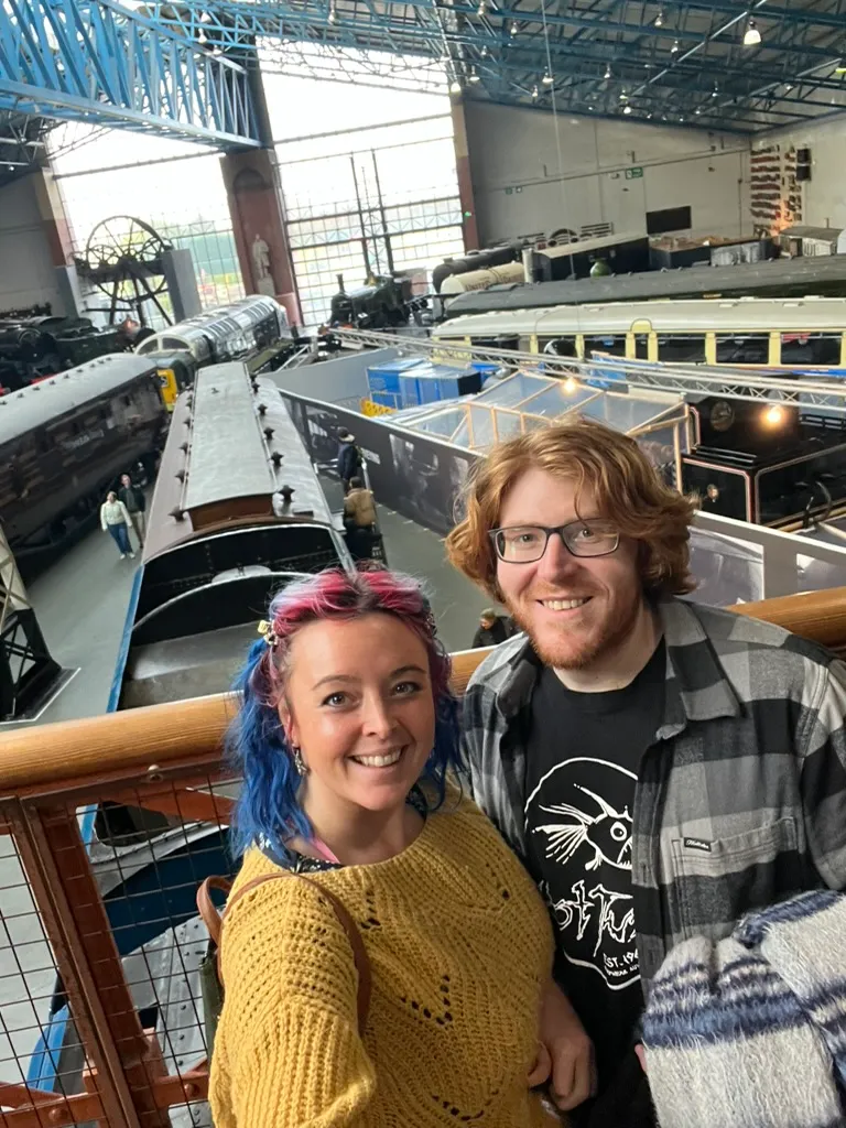 Looking down from the balcony over the Great Hall, rows of carriages and locomotives fanned out below with the big arched window behind