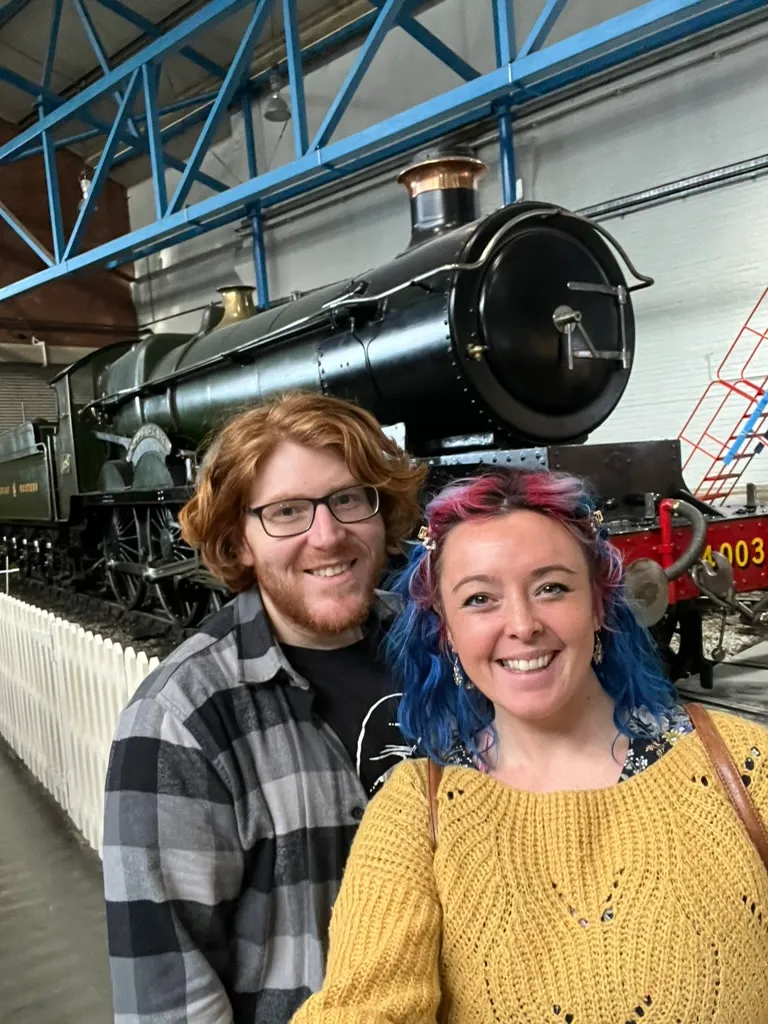 A selfie in front of a green Great Western locomotive numbered 4003 behind a white picket fence